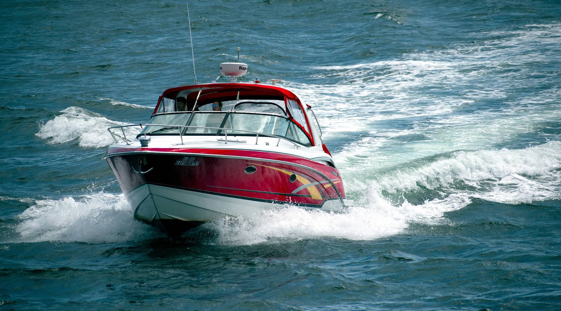Red speedboat racing through blue water